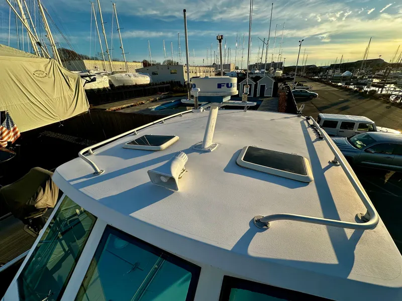 Slide: The Image of 2000 Mainship Pilot 30 Sedan boat docked at marina, showcasing roof and radar equipment. - 8