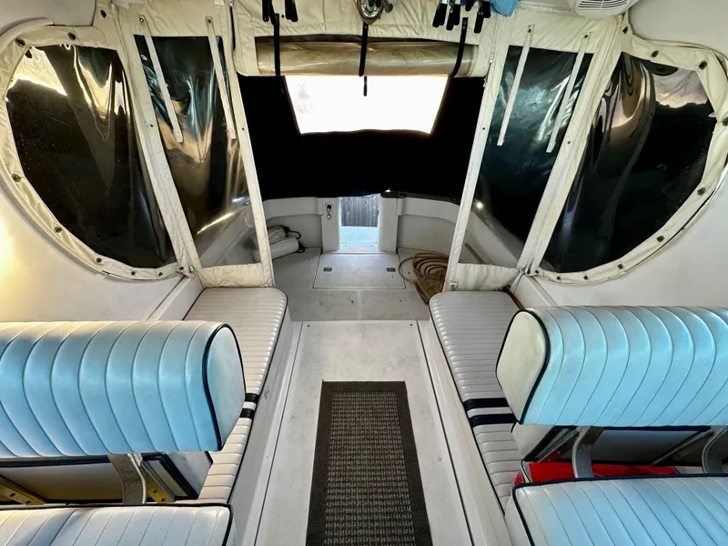 Slide: The Image of Interior of 2000 Mainship Pilot 30 Sedan with blue seating and clear windows. - 9