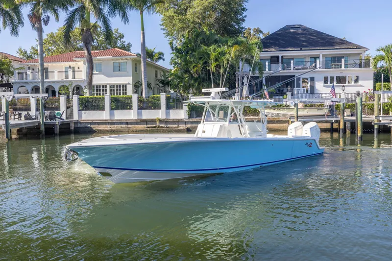 Slide: The Image of 2022 SeaVee 390Z boat docked near waterfront homes and palm trees. - 1