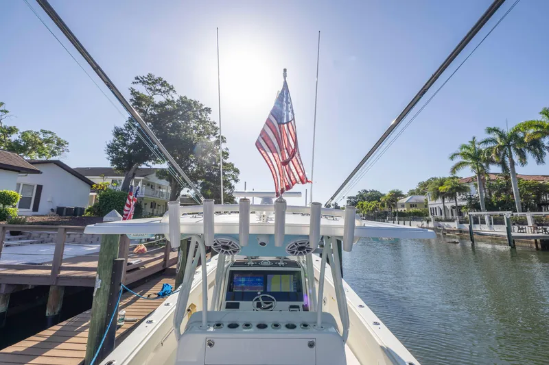 Slide: The Image of 2022 SeaVee 390Z boat docked, American flag, sunny waterfront view. - 15