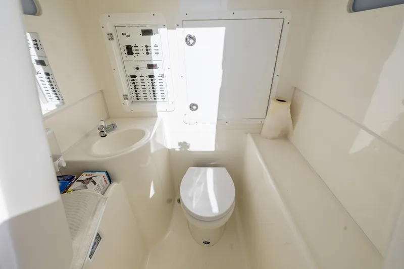 Slide: The Image of 2022 SeaVee 390Z boat bathroom with toilet, sink, and control panel. - 25