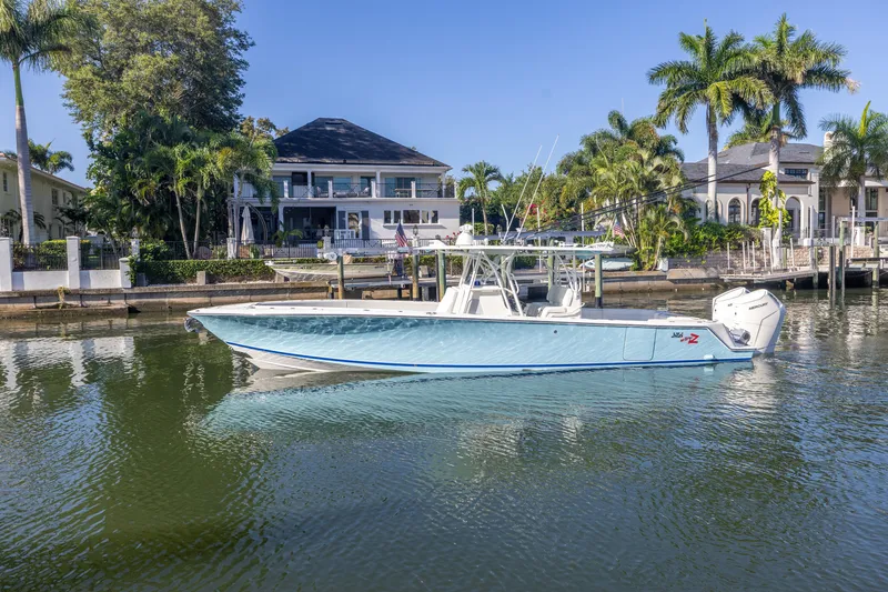 Slide: The Image of 2022 SeaVee 390Z boat docked in a scenic waterfront setting with palm trees. - 3