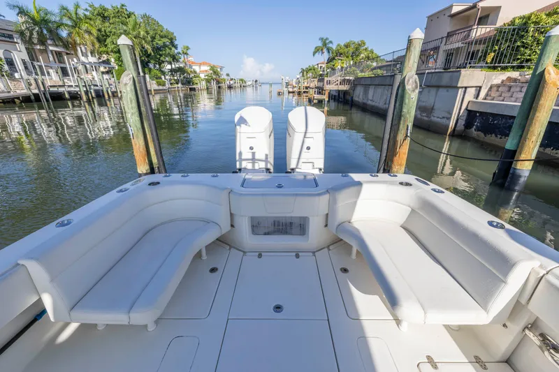 Slide: The Image of 2022 SeaVee 390Z boat with spacious seating, docked in a scenic canal. - 31