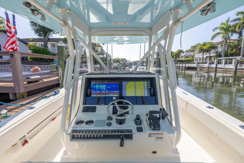 Slide: The Image of 2022 SeaVee 390Z boat helm with advanced navigation system, docked in a scenic canal. - 34