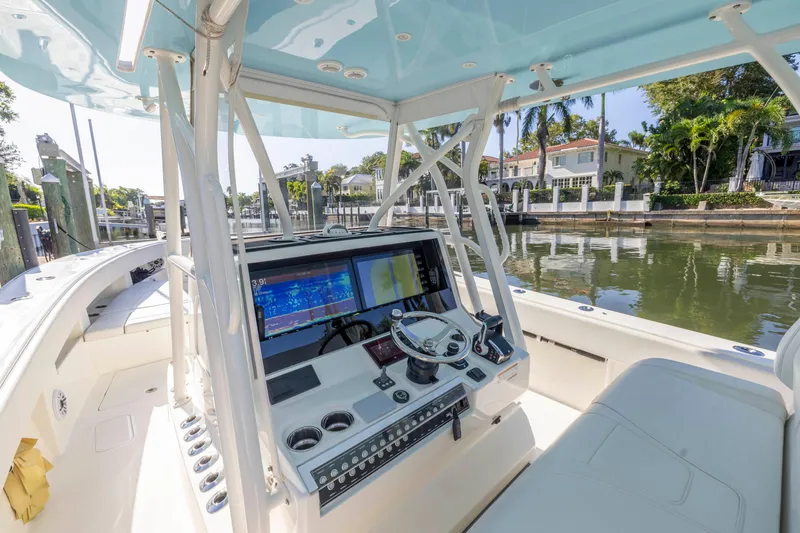 Slide: The Image of 2022 SeaVee 390Z boat cockpit with advanced navigation system, docked by waterfront homes. - 37
