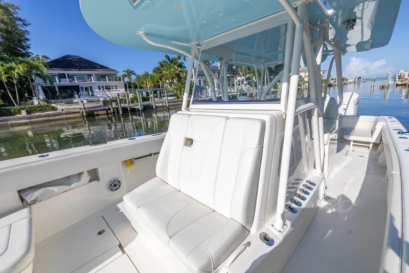 Slide: The Image of 2022 SeaVee 390Z boat with white seating, docked near waterfront homes. - 39
