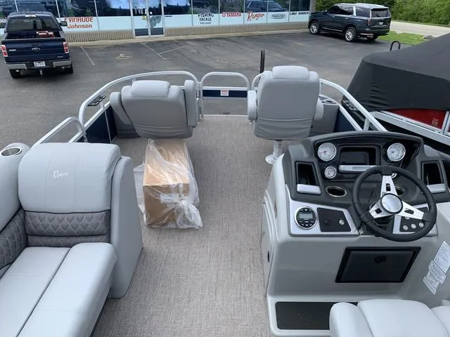 Slide: The Image of 2023 Ranger 220F boat interior with modern dashboard and seating in a dealership lot. - 5