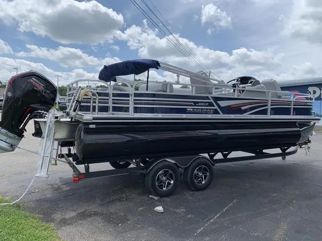 Slide: The Image of 2023 Ranger 220F pontoon boat on trailer under cloudy sky. - 6