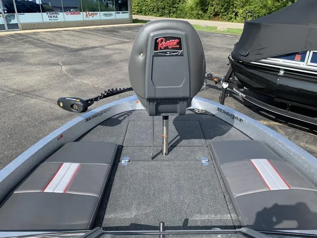 Slide: The Image of 2025 Ranger 212LS boat interior with seating and motor, parked outdoors. - 4