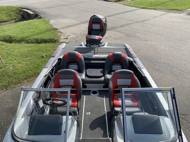 Slide: The Image of 2025 Ranger 212LS boat with red and black seating, parked on a paved surface. - 7