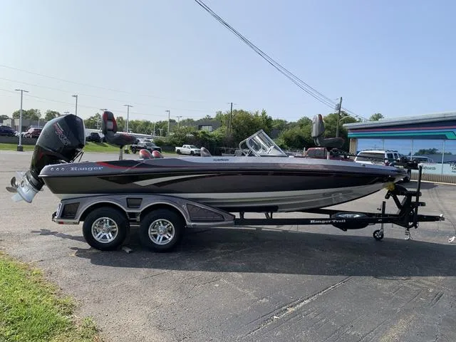 Slide: The Image of 2025 Ranger 212LS boat on trailer, parked outdoors on a sunny day. - 8