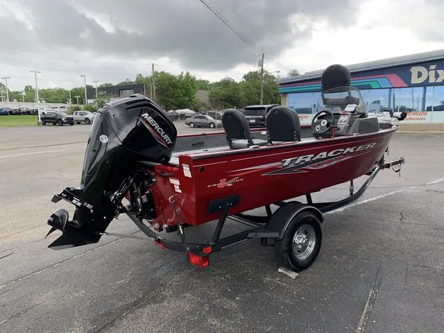 Slide: The Image of 2023 Tracker Pro Guide 16 boat with Mercury engine, parked outdoors. - 5