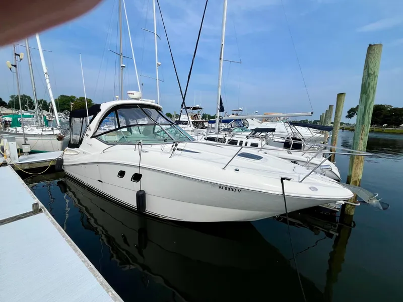 The Image of 2009 Sea Ray 310 Sundancer docked at marina, surrounded by other boats. - 0