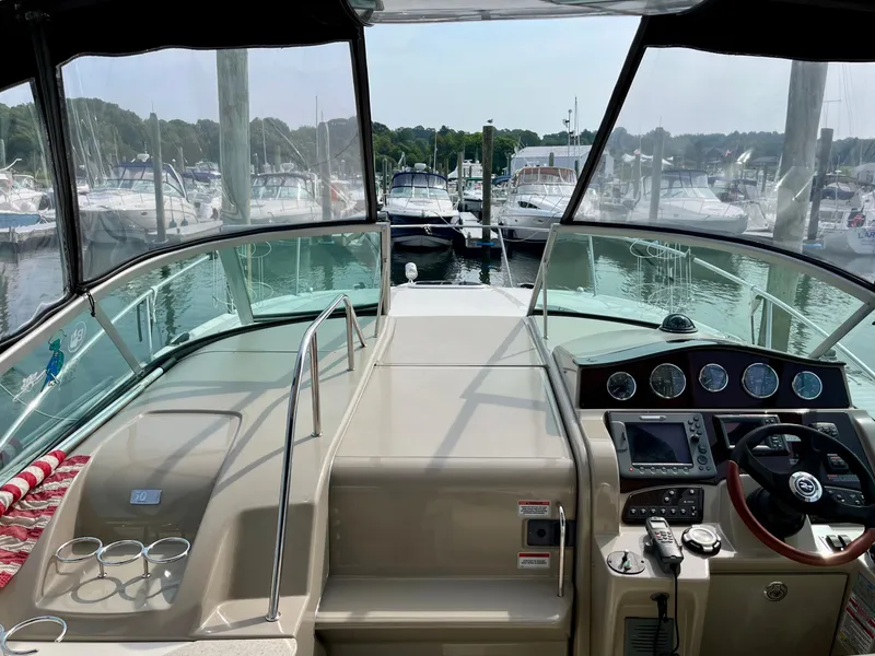 Slide: The Image of 2009 Sea Ray 310 Sundancer cockpit with marina view, featuring steering controls and dashboard. - 12