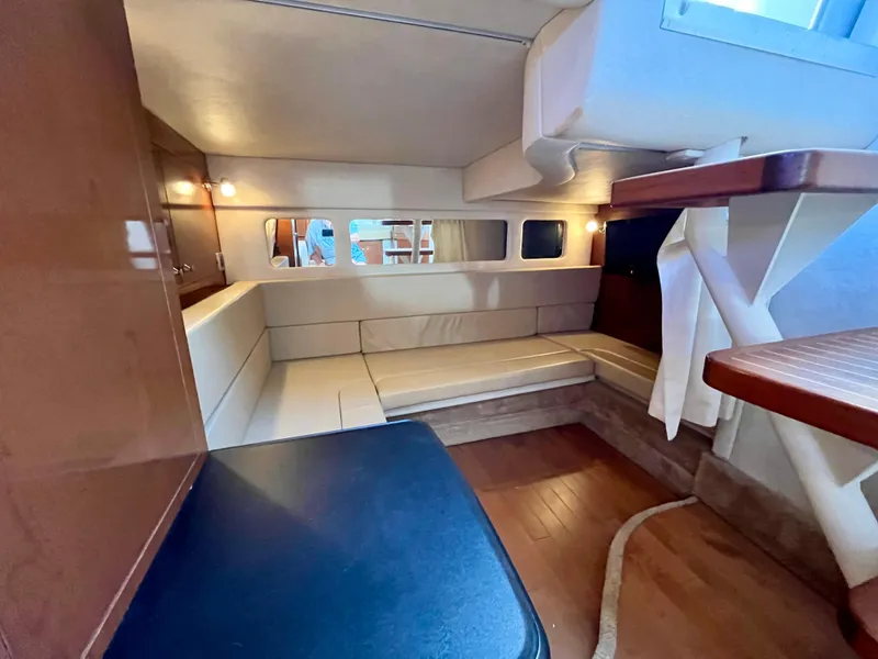Slide: The Image of 2009 Sea Ray 310 Sundancer cabin interior with seating, wood accents, and ambient lighting. - 18