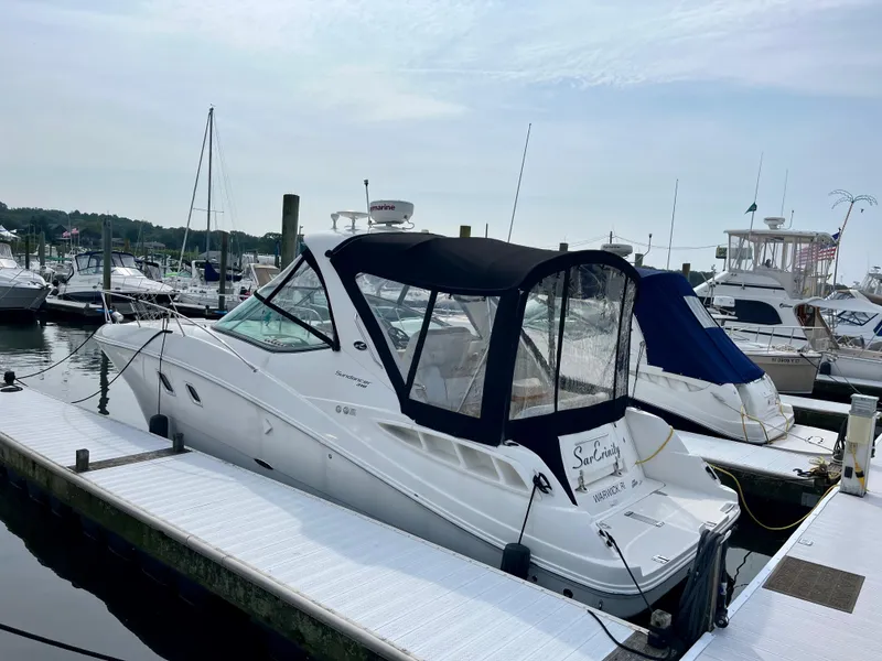 Slide: The Image of 2009 Sea Ray 310 Sundancer docked at marina, featuring sleek design and black canopy. - 2