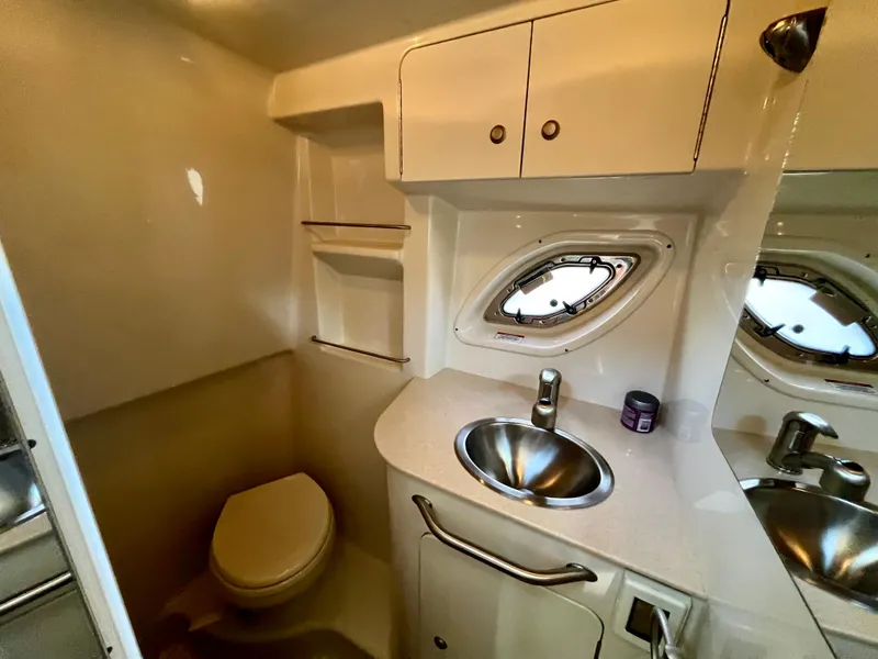 Slide: The Image of 2009 Sea Ray 310 Sundancer bathroom with sink, toilet, and porthole window. - 21