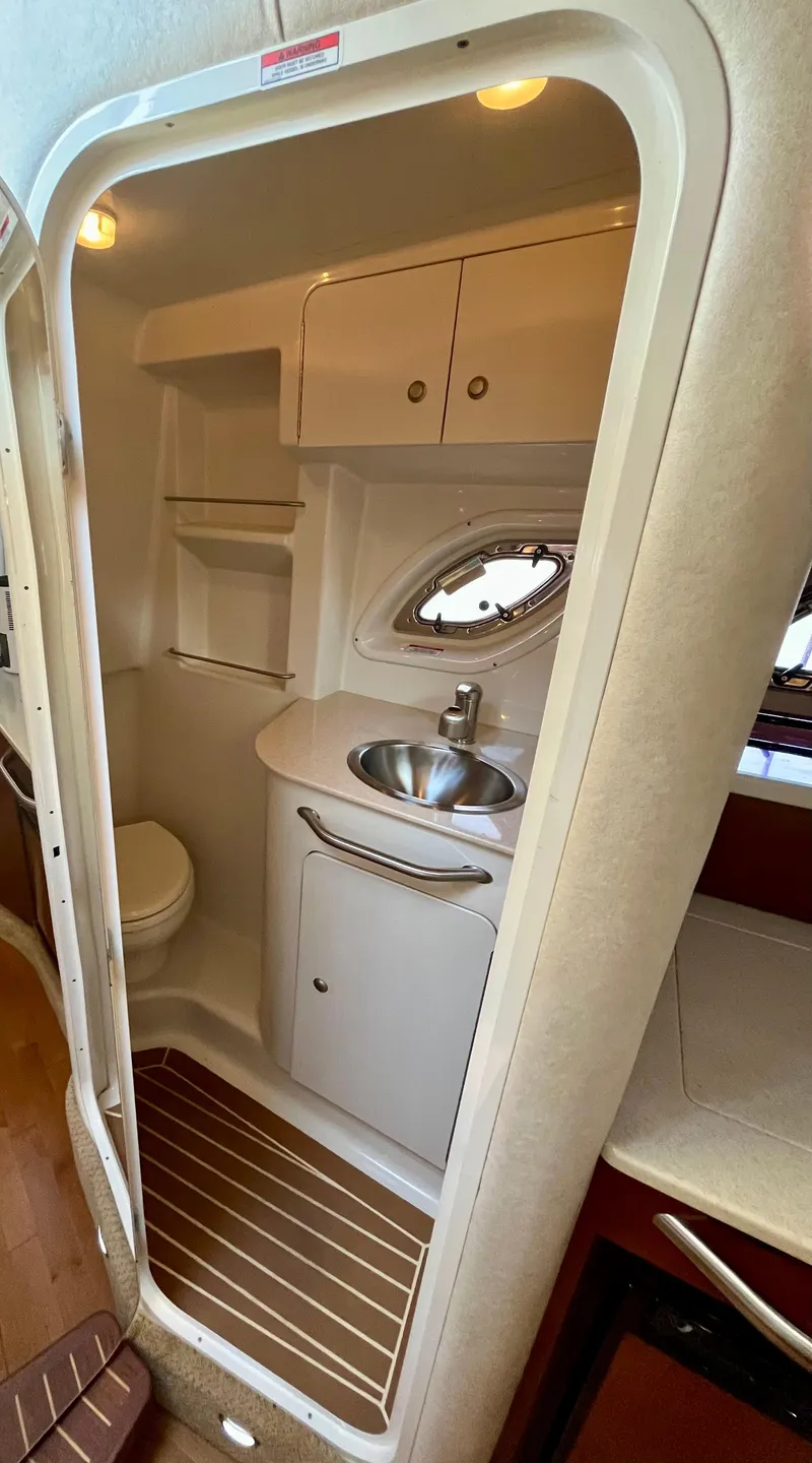 Slide: The Image of 2009 Sea Ray 310 Sundancer bathroom with sink, toilet, and storage cabinets. - 22