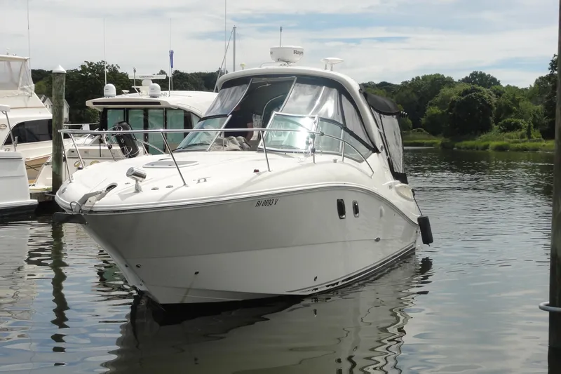 Slide: The Image of 2009 Sea Ray 310 Sundancer yacht docked in a serene marina setting. - 26