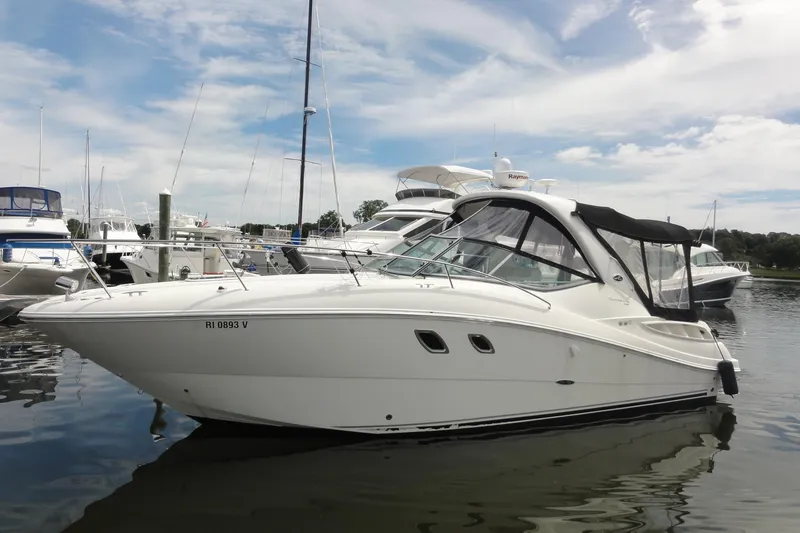 Slide: The Image of 2009 Sea Ray 310 Sundancer boat docked in a marina under a partly cloudy sky. - 27