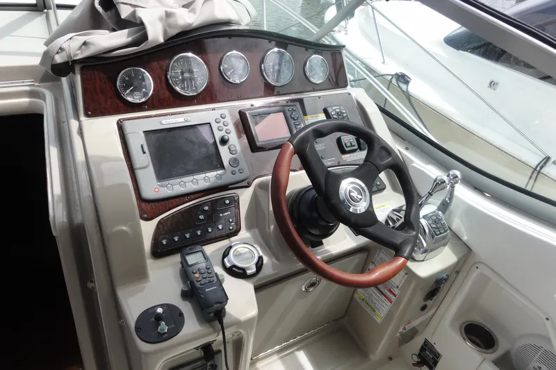 Slide: The Image of Control panel of a 2009 Sea Ray 310 Sundancer boat with steering wheel and navigation instruments. - 34
