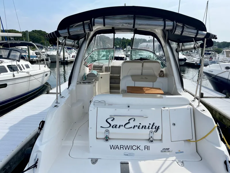 Slide: The Image of 2009 Sea Ray 310 Sundancer boat docked, featuring a canopy and seating area, Warwick, RI. - 4