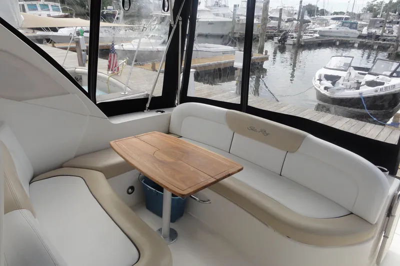 Slide: The Image of 2009 Sea Ray 310 Sundancer interior with seating and table, docked at marina. - 40