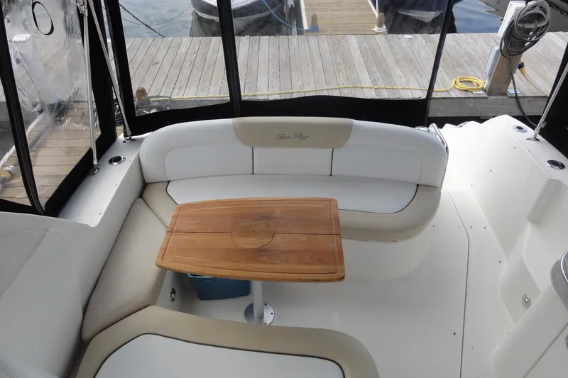 Slide: The Image of 2009 Sea Ray 310 Sundancer cockpit with cushioned seating and wooden table. - 41