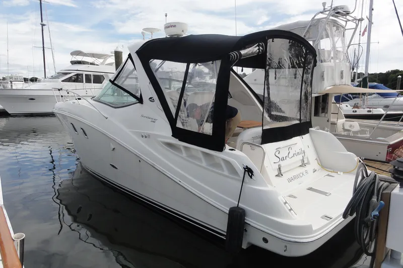 Slide: The Image of 2009 Sea Ray 310 Sundancer docked at marina, featuring sleek design and black canopy. - 46