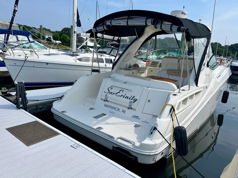 Slide: The Image of 2009 Sea Ray 310 Sundancer docked at marina, featuring sleek design and spacious deck. - 5
