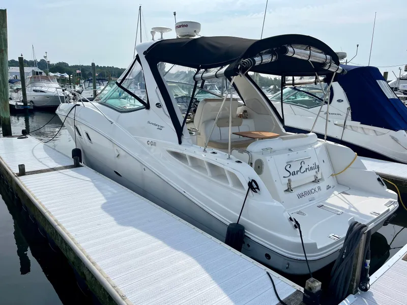 Slide: The Image of 2009 Sea Ray 310 Sundancer boat docked at marina, featuring sleek design and black canopy. - 6