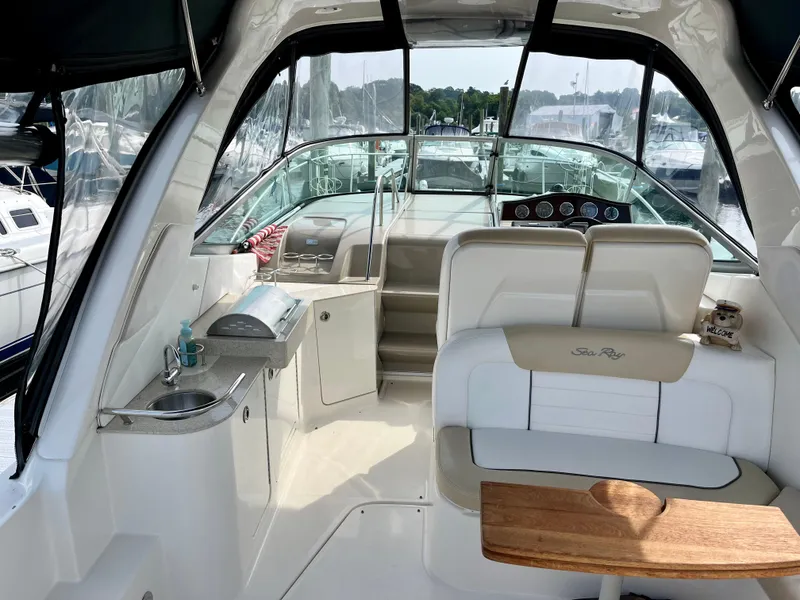 Slide: The Image of 2009 Sea Ray 310 Sundancer interior with helm, seating, and kitchenette. - 7