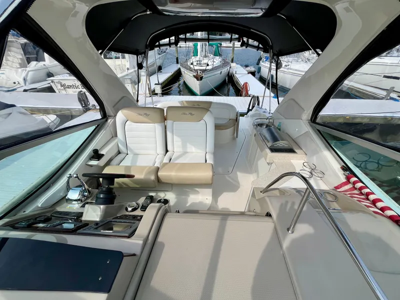 Slide: The Image of 2009 Sea Ray 310 Sundancer interior with helm, seating, and marina view. - 8
