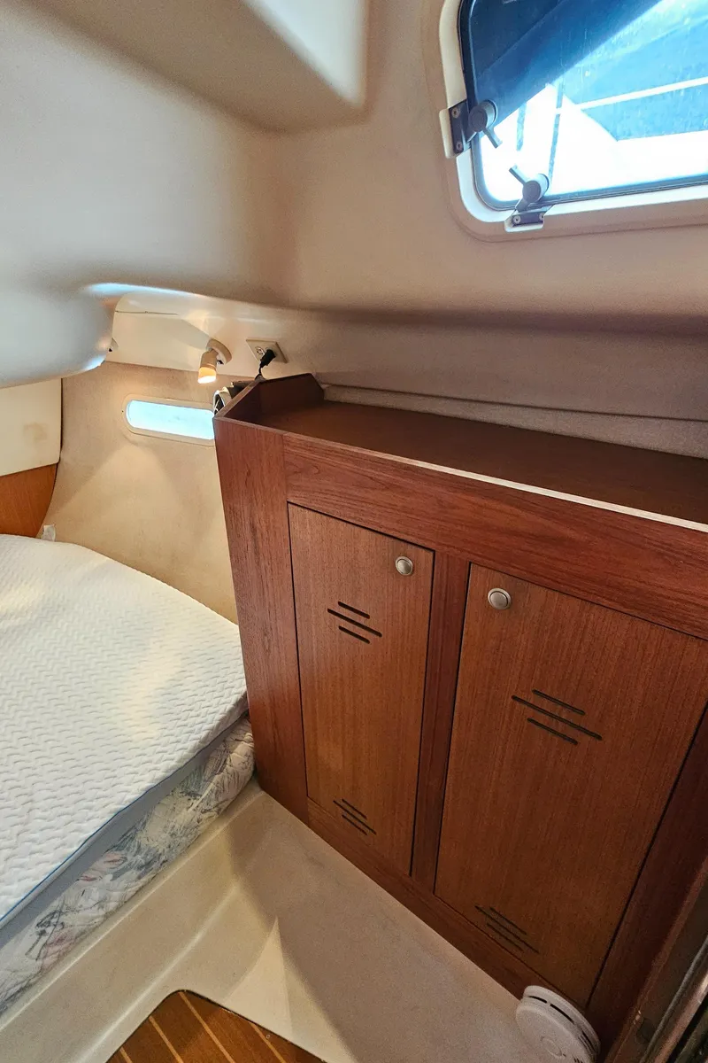 Slide: The Image of 1998 Hunter 340 Sloop cabin interior with wooden cabinet and bed. - 10