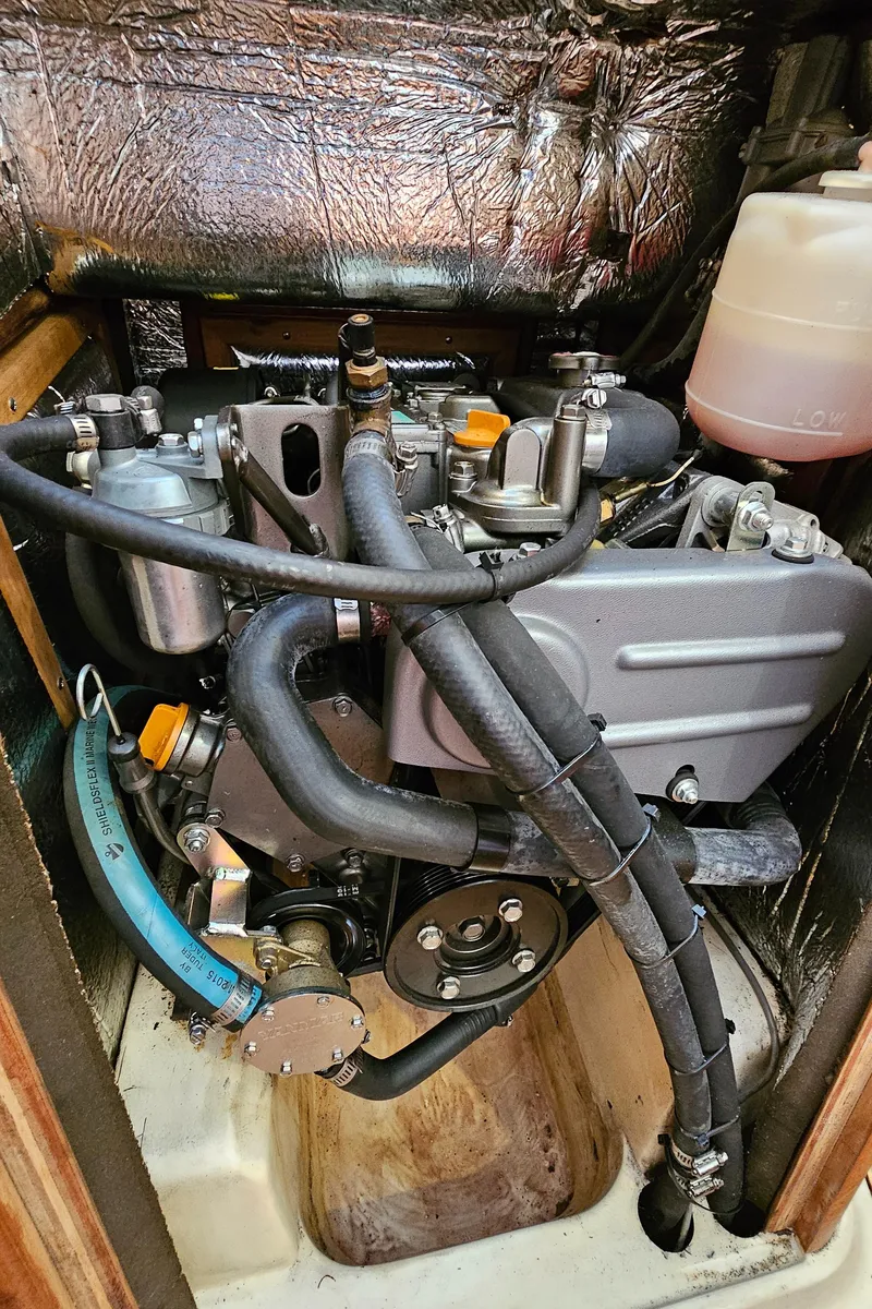 Slide: The Image of 1998 Hunter 340 Sloop engine compartment with visible hoses and components. - 15