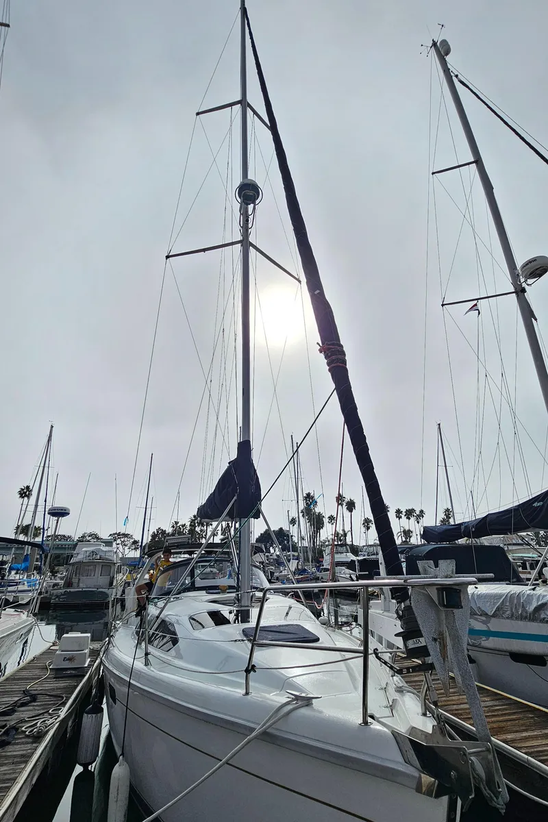 Slide: The Image of 1998 Hunter 340 Sloop sailboat docked at marina under cloudy sky. - 2