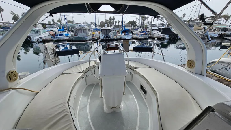 Slide: The Image of 1998 Hunter 340 Sloop cockpit view in marina, showcasing helm and seating area. - 4