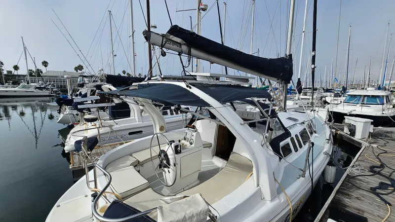 Slide: The Image of 1998 Hunter 340 Sloop sailboat docked in a marina, surrounded by other boats. - 5