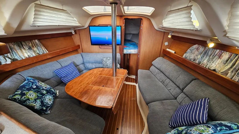 Slide: The Image of Interior of 1998 Hunter 340 Sloop with cozy seating and wooden table. - 7