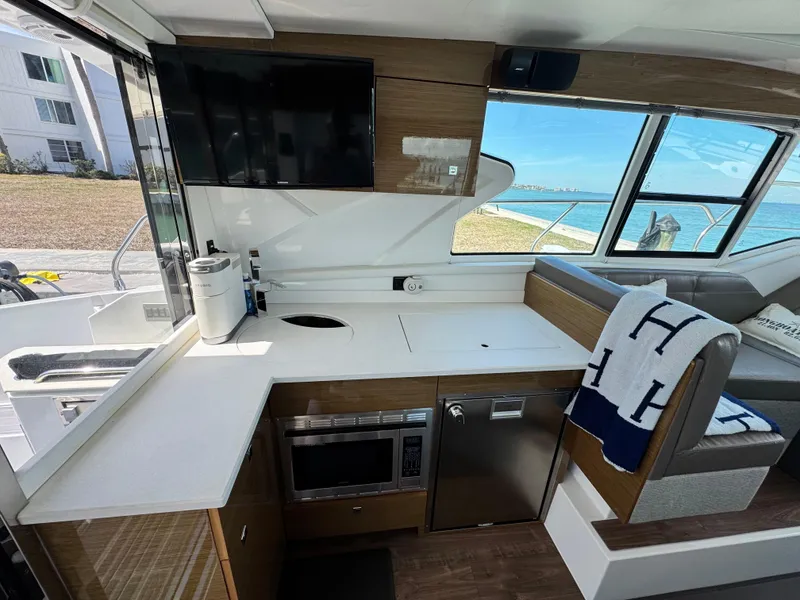 Slide: The Image of Interior of 2019 Cruisers Yachts 42 Cantius, featuring modern kitchen and scenic window view. - 14