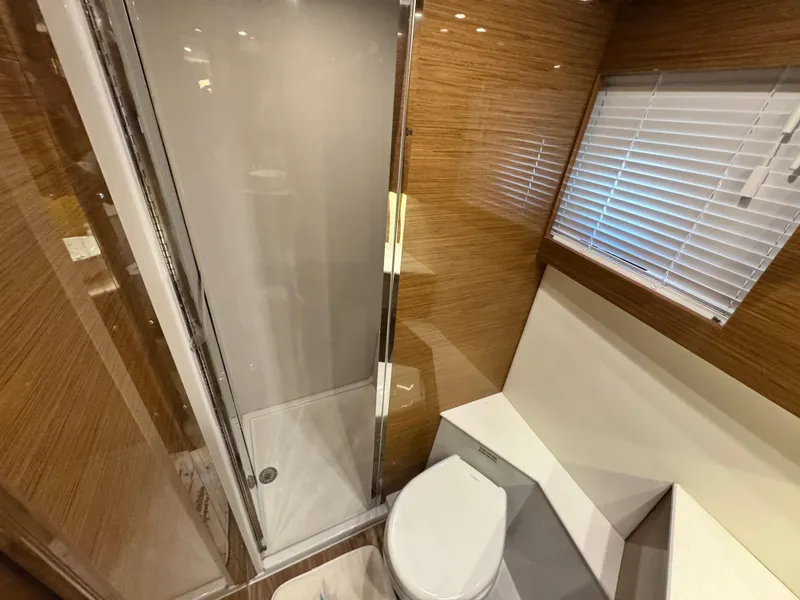 Slide: The Image of 2019 Cruisers Yachts 42 Cantius bathroom with shower, toilet, and wooden accents. - 27