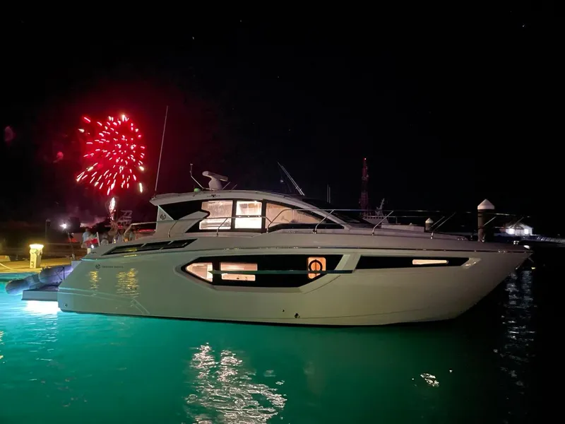 Slide: The Image of 2019 Cruisers Yachts 42 Cantius at night with fireworks in the background. - 42