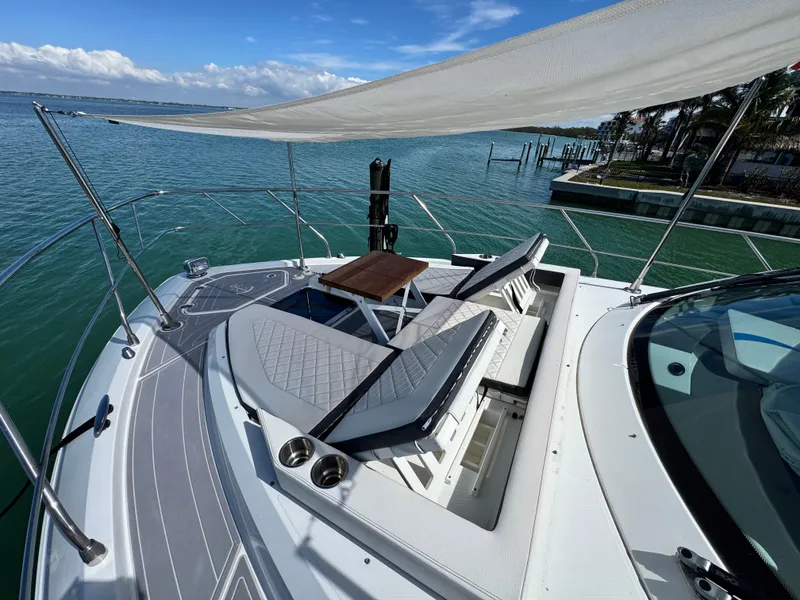 Slide: The Image of 2019 Cruisers Yachts 42 Cantius with sun loungers on deck, overlooking serene waters. - 5