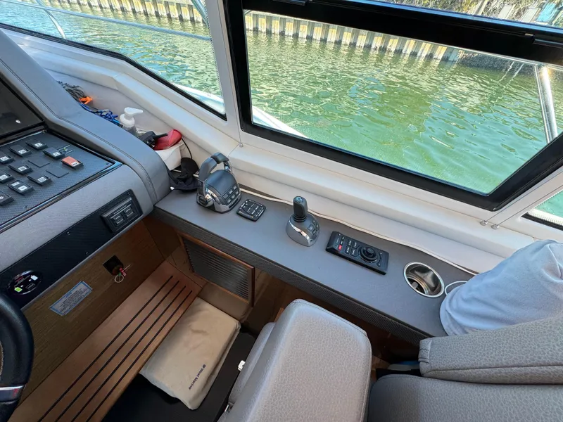 Slide: The Image of Interior helm of 2019 Cruisers Yachts 42 Cantius with control panel and water view. - 21