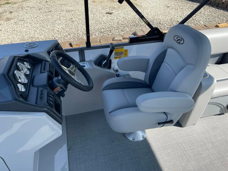 Slide: The Image of 2025 Bentley Pontoons Legacy 203 Navigator helm with plush captain's chair and modern dashboard. - 10