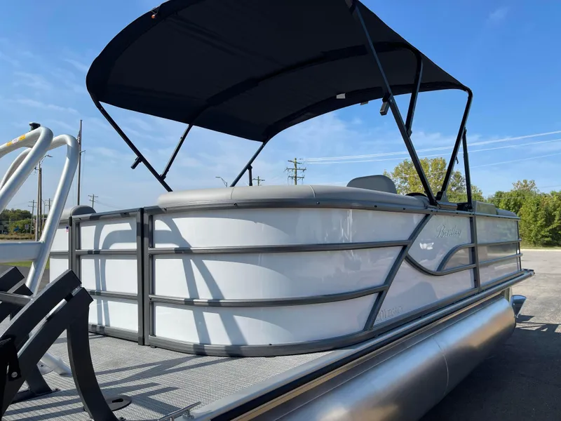 Slide: The Image of 2025 Bentley Pontoons Legacy 203 Navigator with canopy, docked under clear blue sky. - 4
