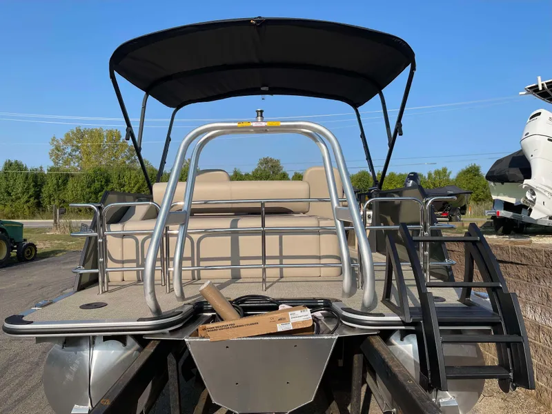 Slide: The Image of 2025 Bentley Pontoons Legacy 203 Swingback with canopy and seating, docked outdoors. - 4