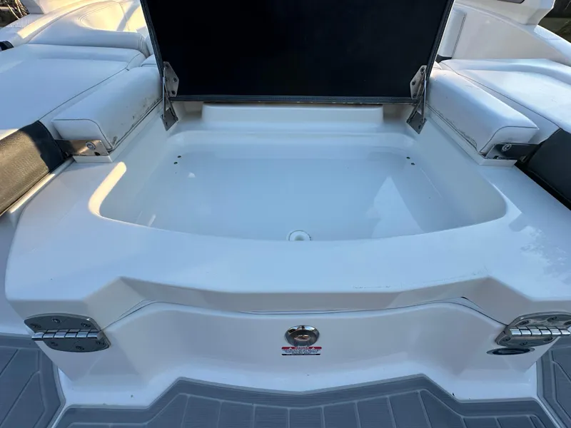 Slide: The Image of 2019 Chaparral 237 SSX boat with open storage compartment, white interior, and cushioned seating. - 15