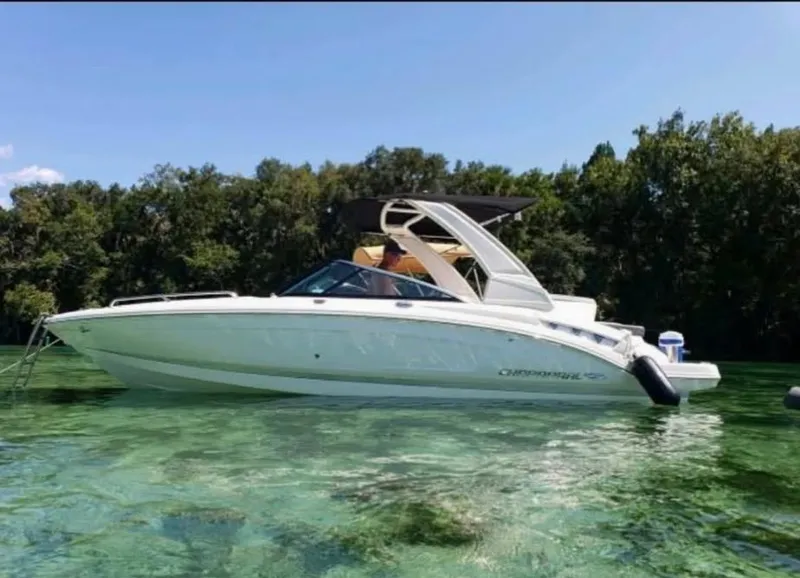 Slide: The Image of 2019 Chaparral 237 SSX boat on clear water near lush greenery. - 2