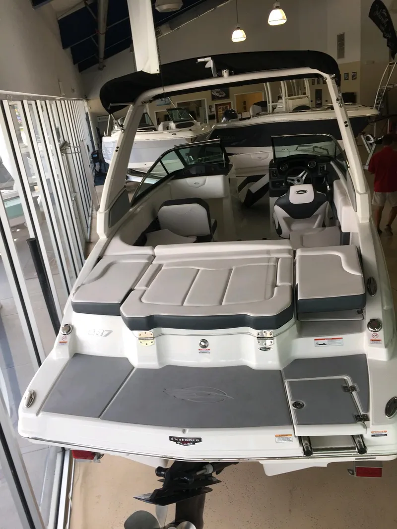 Slide: The Image of 2019 Chaparral 237 SSX boat interior with seating and dashboard in showroom. - 8